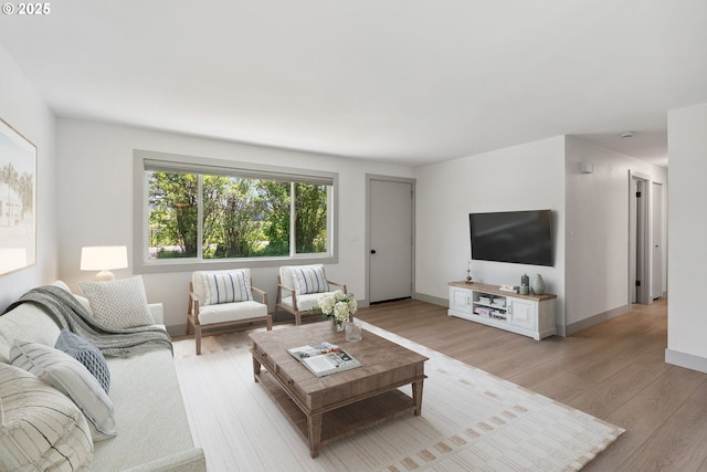 living area with light wood-style floors and baseboards