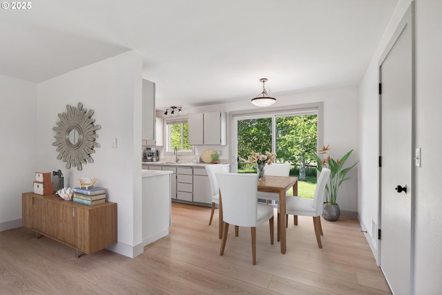dining room featuring baseboards and light wood-type flooring