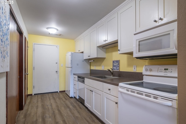 kitchen with white appliances, a sink, dark wood finished floors, and white cabinetry