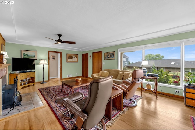 1815 SE 97th Ave, Vancouver, WA 98664 - living area with ceiling fan, light wood-style flooring, baseboards, and a wood stove