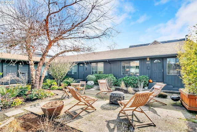 back of property featuring an outdoor fire pit, board and batten siding, and a patio area