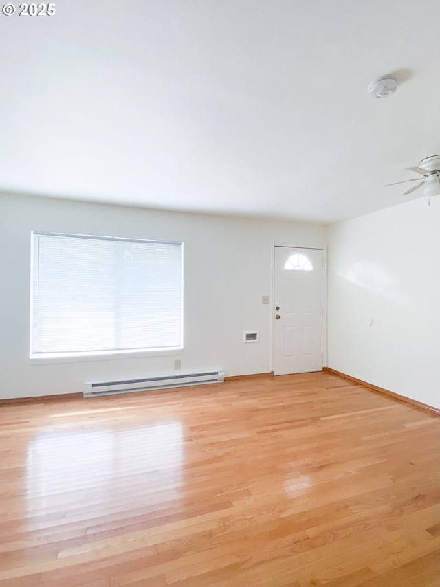 unfurnished living room with a ceiling fan, visible vents, baseboards, a baseboard radiator, and light wood-type flooring