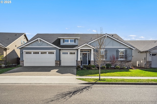 craftsman-style home featuring roof with shingles, an attached garage, stone siding, driveway, and a front lawn