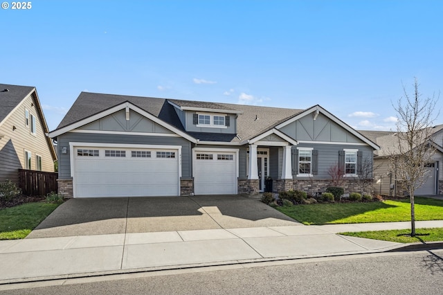 craftsman inspired home featuring a garage, a front yard, concrete driveway, and stone siding