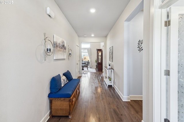 corridor featuring dark wood finished floors and baseboards