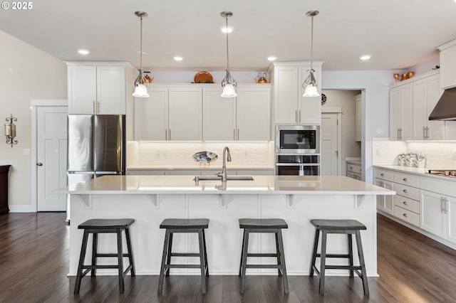 kitchen featuring stainless steel appliances, a sink, light countertops, and white cabinets