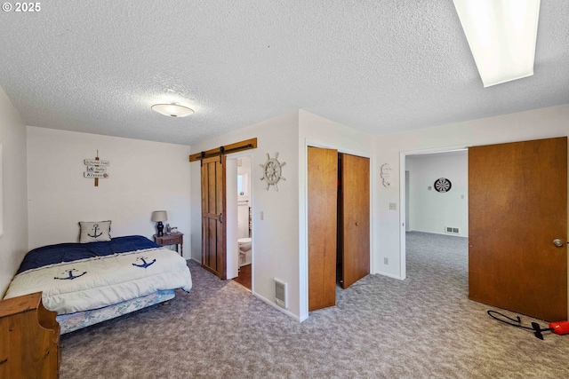 91256 Cape Arago Hwy, Coos Bay, OR 97420 - carpeted bedroom with a barn door, a textured ceiling, a closet, and baseboards