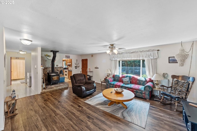 91256 Cape Arago Hwy, Coos Bay, OR 97420 - living room featuring wood finished floors, a wood stove, and a ceiling fan