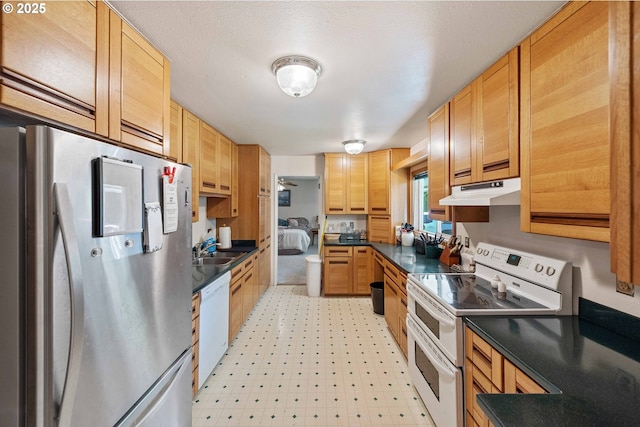 91256 Cape Arago Hwy, Coos Bay, OR 97420 - kitchen featuring white appliances, under cabinet range hood, dark countertops, and light flooring