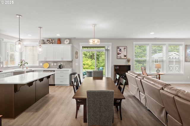 dining room featuring plenty of natural light, sink, and light hardwood / wood-style flooring