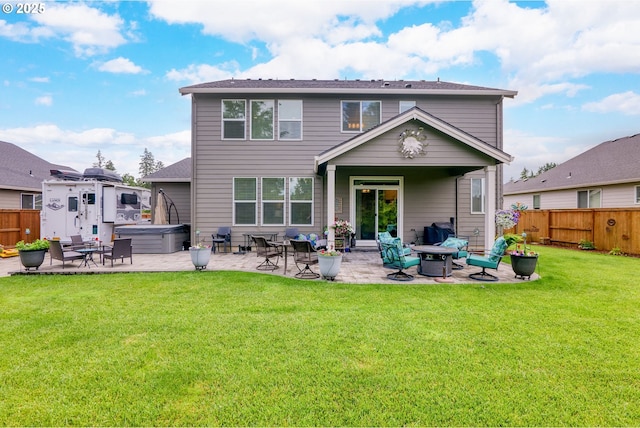 rear view of house with a patio area, a hot tub, and a lawn