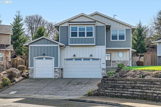 view of front of house with driveway, a garage, stone siding, fence, and board and batten siding