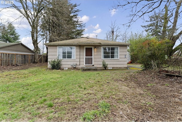 view of front of home with a front yard and fence