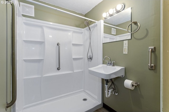 bathroom featuring a stall shower and visible vents