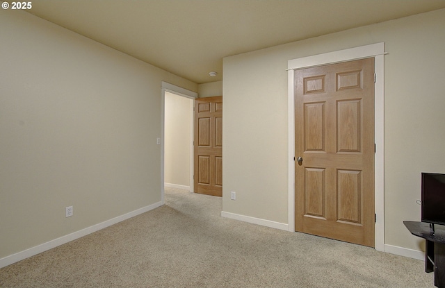 unfurnished bedroom featuring light colored carpet and a closet