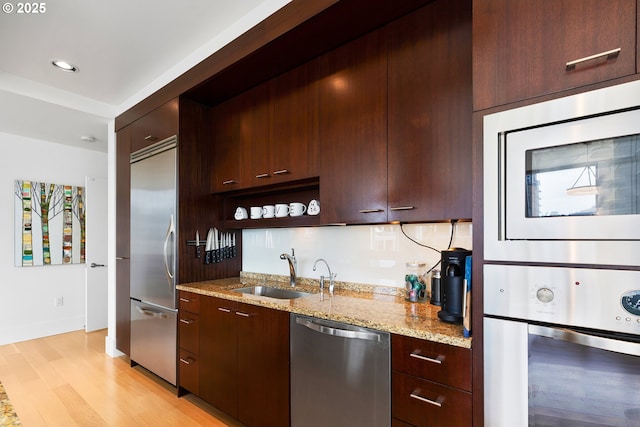 1001 NW Lovejoy St Unit 710, Portland, OR 97209 - kitchen featuring built in appliances, light wood-style flooring, modern cabinets, light stone counters, and open shelves