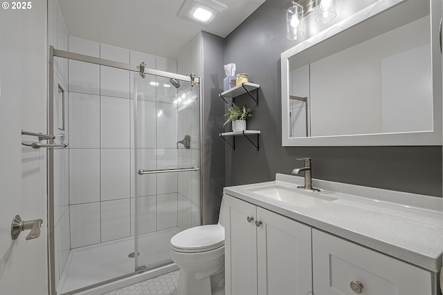 bathroom with vanity, a shower with shower door, and toilet