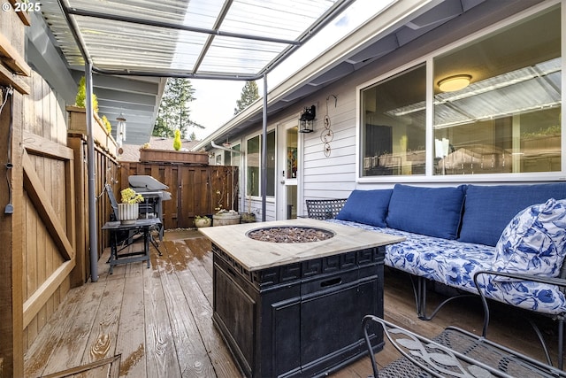 wooden terrace featuring grilling area and an outdoor living space with a fire pit