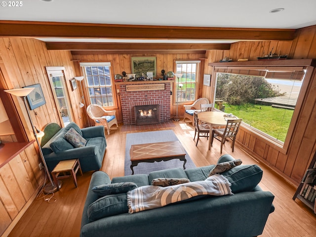 living area featuring wood walls, light wood-style flooring, and a fireplace