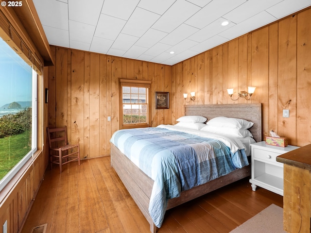 bedroom featuring wooden walls and wood-type flooring