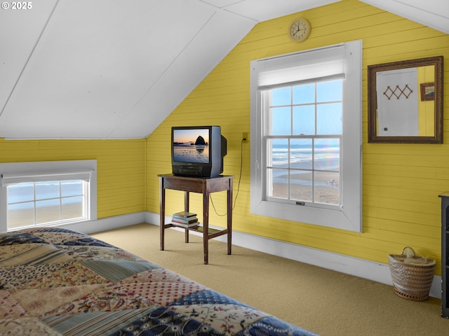 carpeted bedroom featuring lofted ceiling and wooden walls
