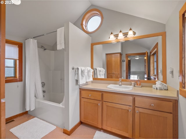 full bathroom featuring lofted ceiling, vanity, shower / bath combo with shower curtain, and baseboards