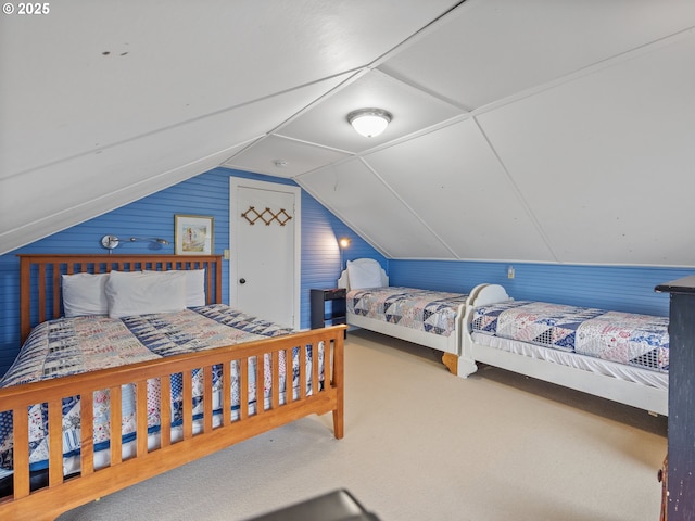 bedroom with vaulted ceiling, carpet floors, and wood walls