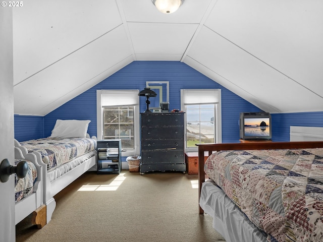 bedroom featuring multiple windows, lofted ceiling, carpet, and wooden walls