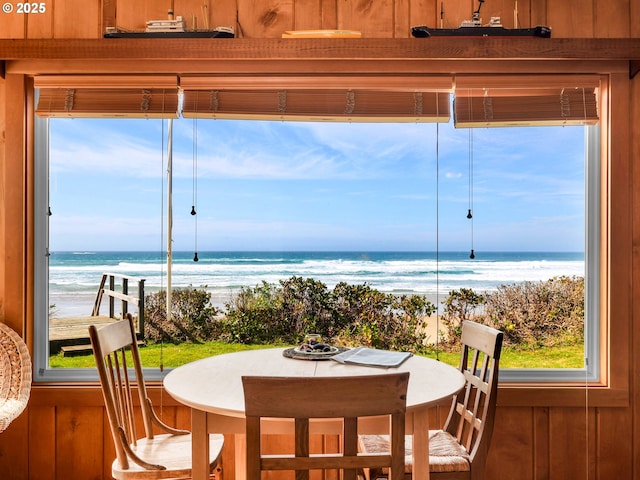 sunroom / solarium featuring view of water and beach and healthy amount of natural light