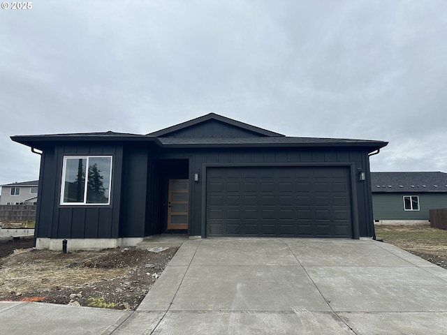 view of front of property with board and batten siding, concrete driveway, and an attached garage