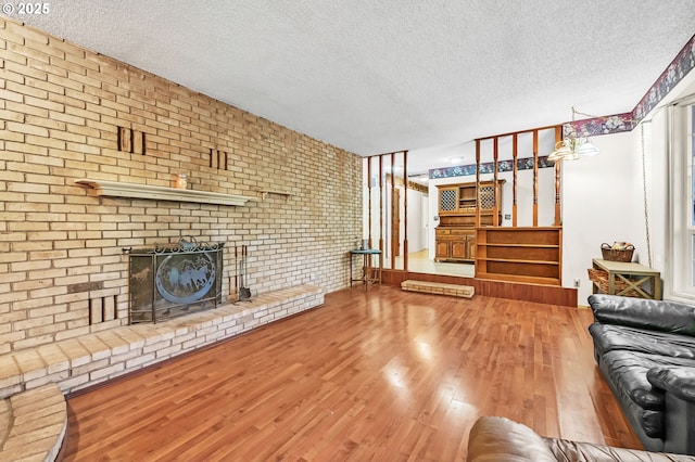 32739 Taylor Butte Rd, Cottage Grove, OR 97424 - unfurnished living room with a textured ceiling, wood finished floors, a fireplace, and brick wall