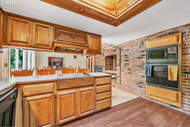 32739 Taylor Butte Rd, Cottage Grove, OR 97424 - kitchen featuring black appliances, brick wall, light wood-style flooring, light countertops, and brown cabinetry