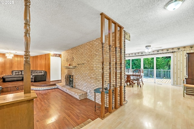 32739 Taylor Butte Rd, Cottage Grove, OR 97424 - living area with a textured ceiling, ceiling fan, wood finished floors, a brick fireplace, and brick wall