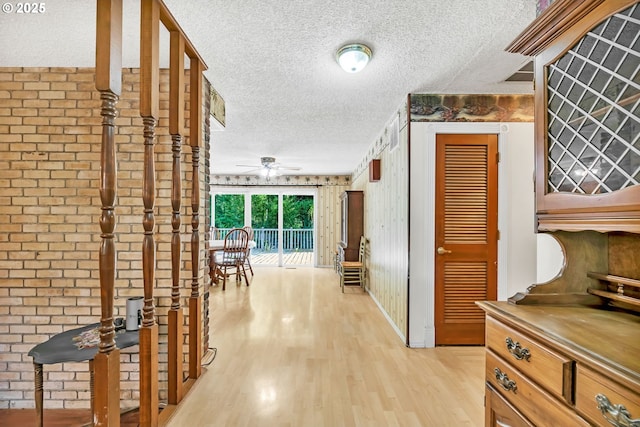 32739 Taylor Butte Rd, Cottage Grove, OR 97424 - corridor featuring a textured ceiling, light wood-style floors, and brick wall