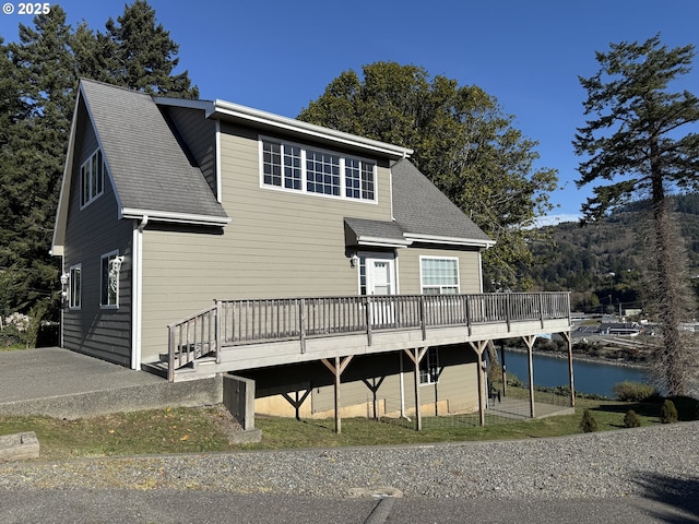 back of property with a deck with water view