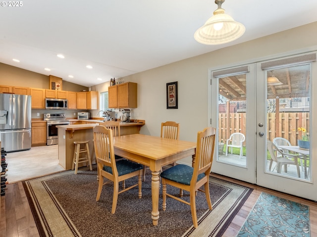 dining area with lofted ceiling, light wood-type flooring, recessed lighting, and french doors