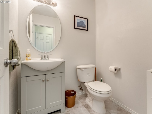 bathroom with toilet, baseboards, and vanity