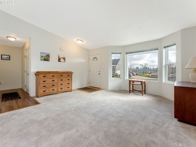 unfurnished living room featuring vaulted ceiling and carpet flooring