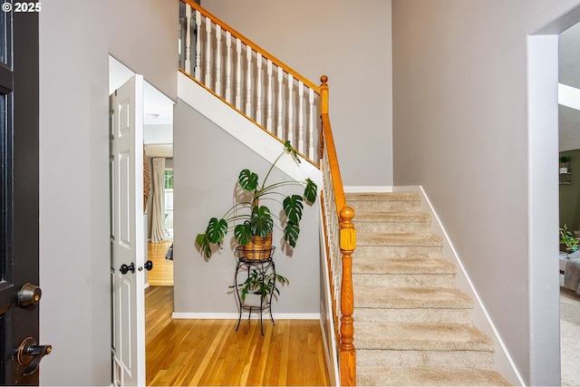 staircase featuring baseboards and wood finished floors