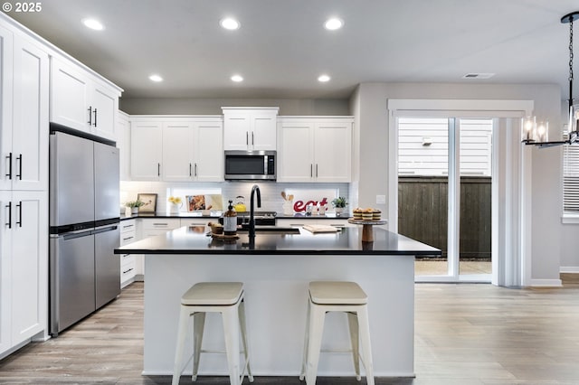 6429 SE Provence St, Hillsboro, OR 97123 - kitchen with stainless steel appliances, dark countertops, a sink, light wood finished floors, and recessed lighting