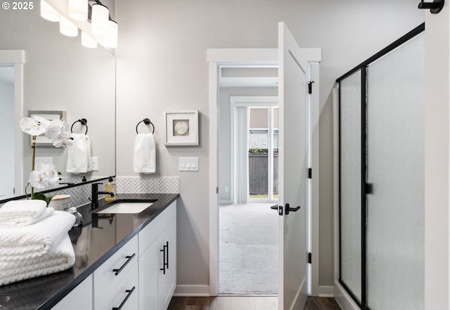 6429 SE Provence St, Hillsboro, OR 97123 - full bath with a stall shower, baseboards, wood finished floors, double vanity, and backsplash