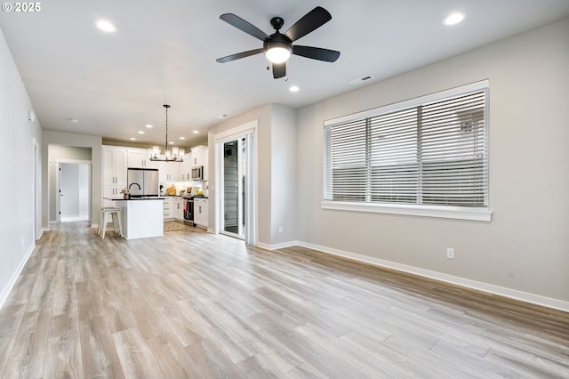 6429 SE Provence St, Hillsboro, OR 97123 - unfurnished living room with a chandelier, light wood-style flooring, baseboards, recessed lighting, and a ceiling fan