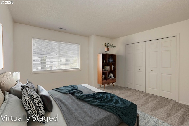 bedroom with carpet floors, a textured ceiling, and a closet