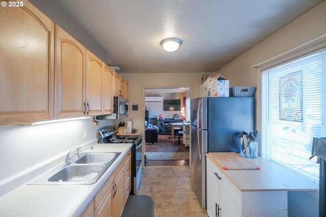 kitchen with stainless steel appliances, sink, and light brown cabinetry