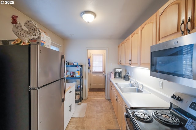 kitchen featuring stainless steel appliances, sink, and light brown cabinets