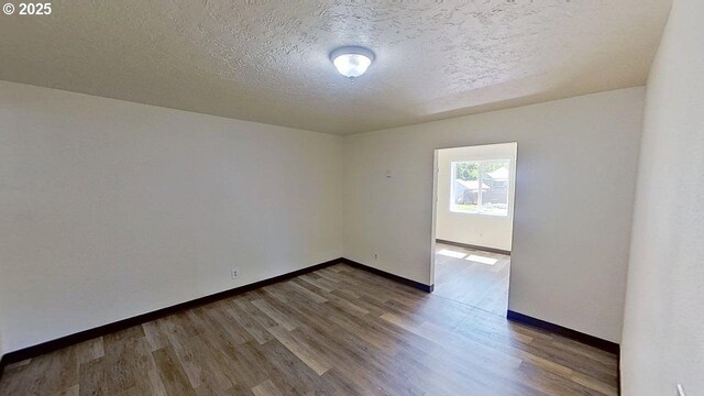 132 NE Rifle Range St, Roseburg, OR 97470 - unfurnished room featuring a textured ceiling, wood finished floors, and baseboards