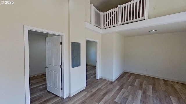 132 NE Rifle Range St, Roseburg, OR 97470 - spare room featuring wood finished floors, a towering ceiling, electric panel, and baseboards