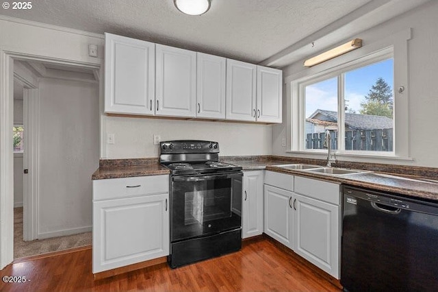 kitchen featuring black appliances, dark countertops, dark wood-style flooring, white cabinetry, and a textured ceiling
