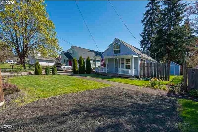 bungalow with a porch, a storage unit, and an outbuilding