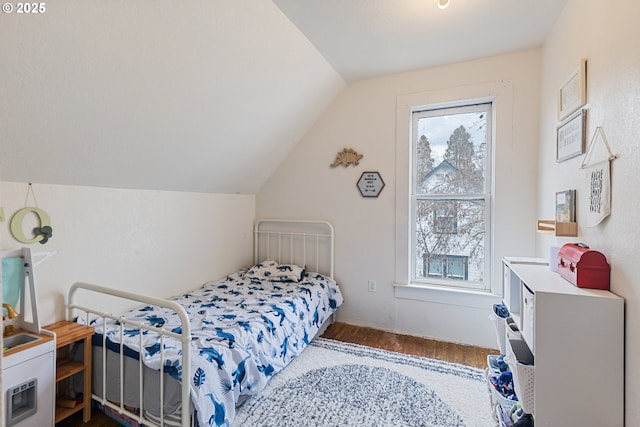 bedroom with dark wood-style floors, multiple windows, and lofted ceiling